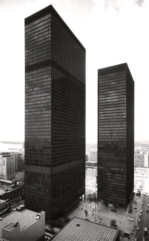 A grayscale photo of the two TD towers: tall, dark, skyscrapers that tower over the surrounding infrastructure.